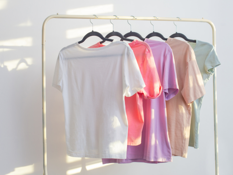 Display of colorful t-shirts on hangers showcasing a versatile clothing collection for all seasons.