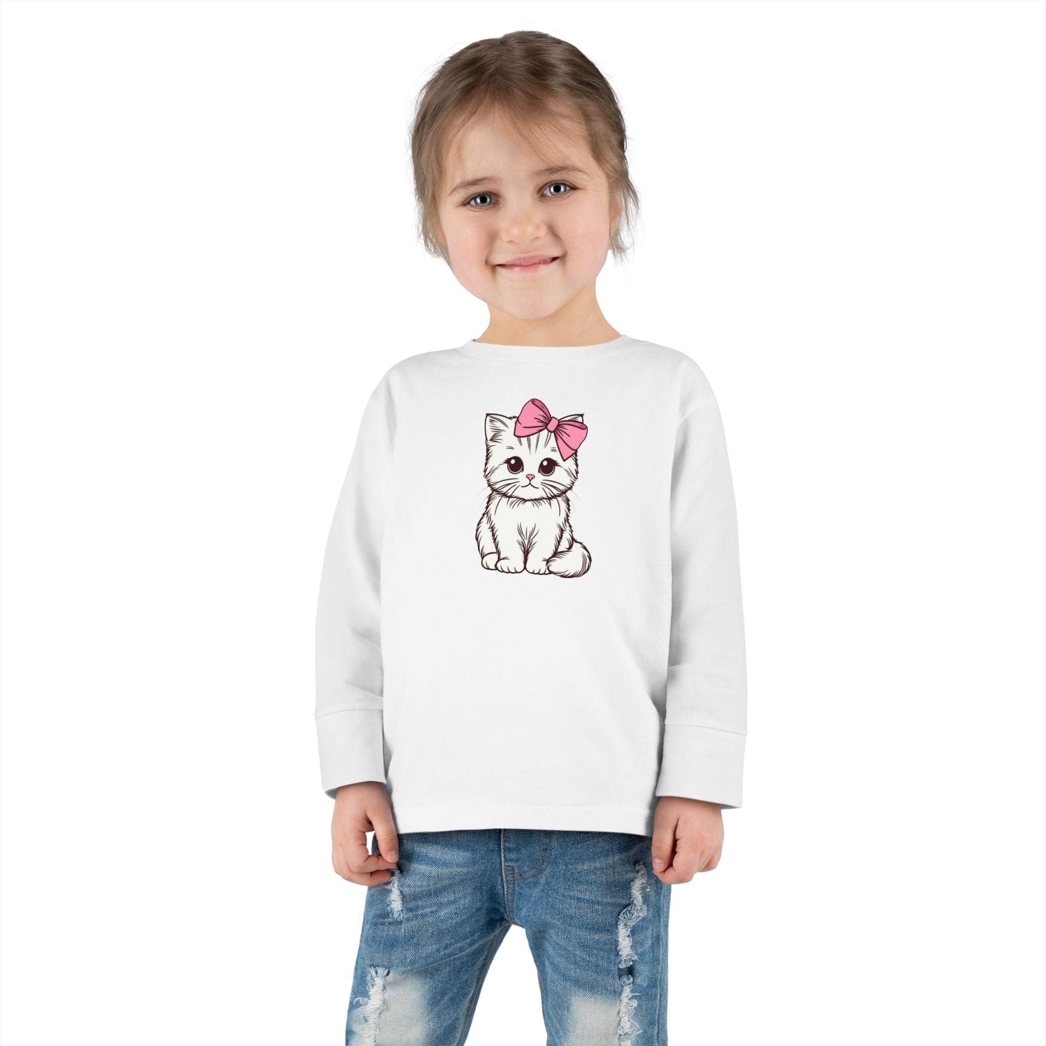 Toddler girl wearing a white long sleeve tee with a cute kitten design and a pink bow.