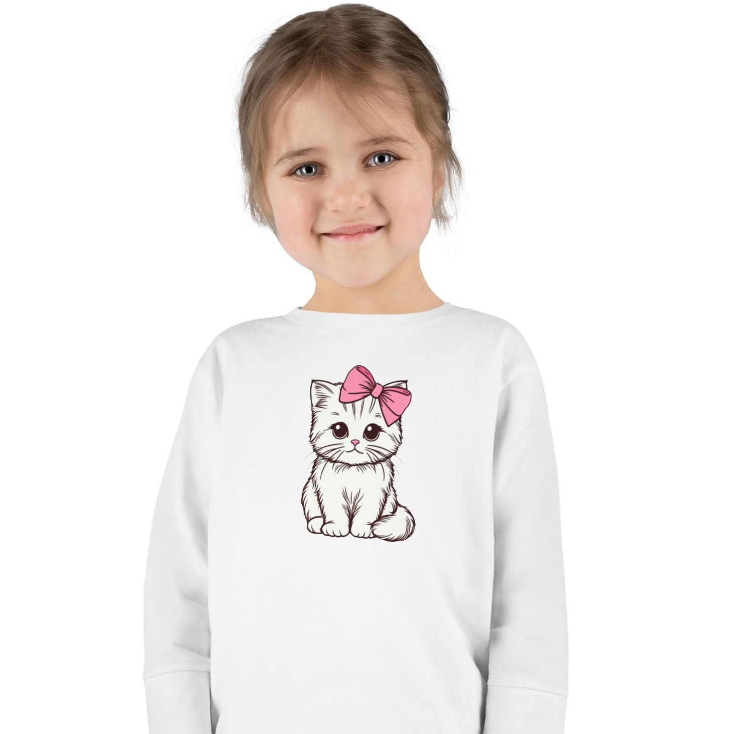 Toddler girl smiling in a long sleeve shirt featuring a cute kitten with a pink bow design.