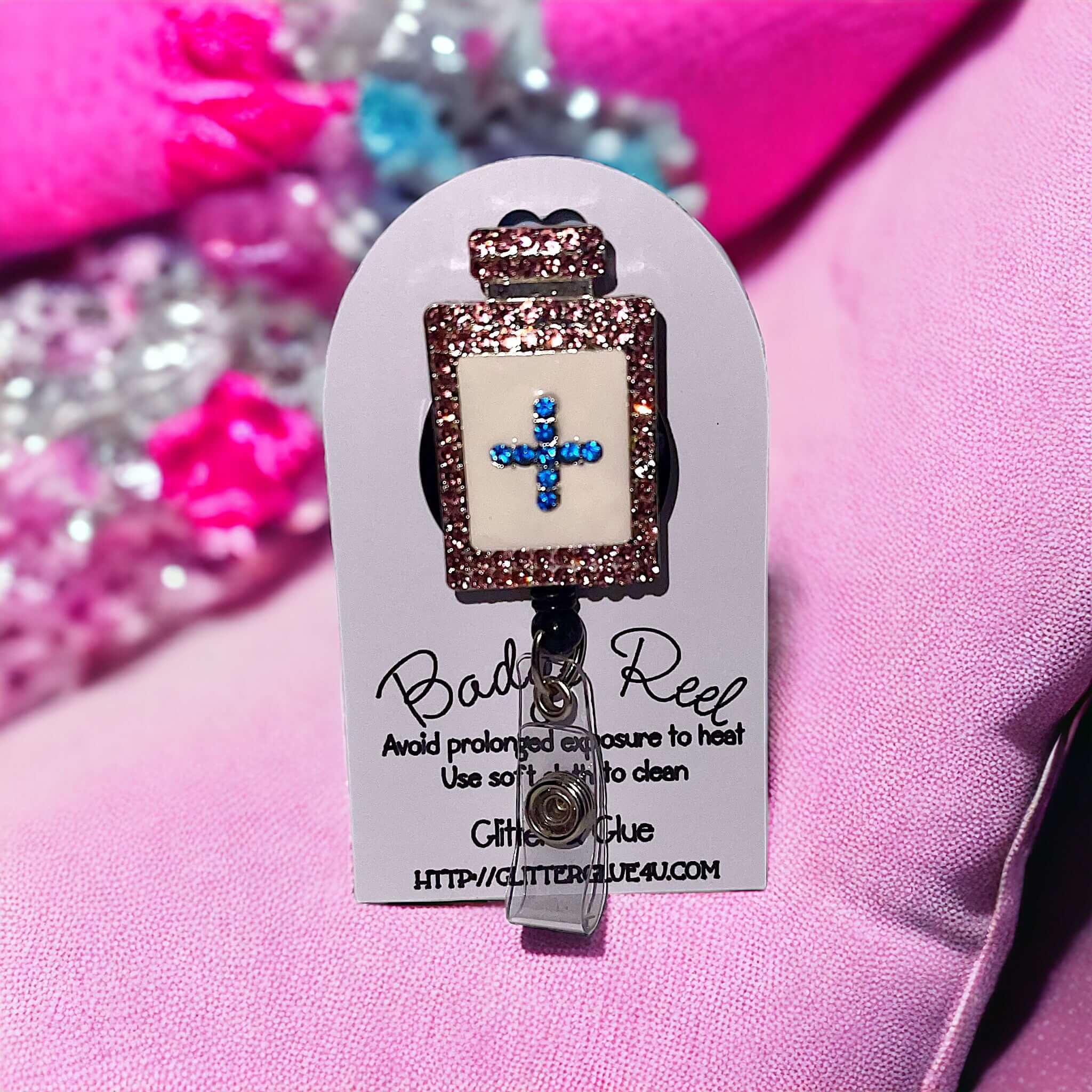 Rhinestone healthcare badge reel featuring a blue cross design, ideal for healthcare workers' uniforms.